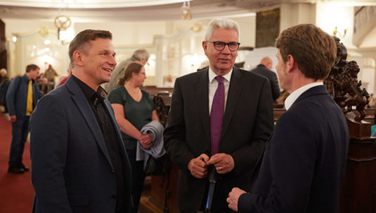 Andreas Mende und Dr. Thorsten Minuth, Konzerngeschäftsführer der Immanuel Albertinen Diakonie, unterhalten sich mit Gästen im Kirchensaal beim 10. Herzbrücke-Benefizkonzert im Hamburger „Michel“ der Albertinen-Stiftung.