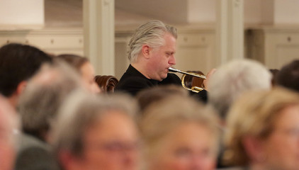 Ein Trompeter spielt inmitten des Publikums im Kirchensaal beim 10. Herzbrücke-Benefizkonzert im Hamburger „Michel“ der Albertinen-Stiftung.