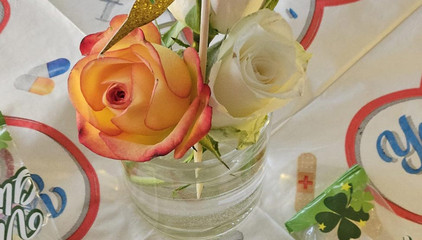 Eine gläserne Vase mit mehreren Rosen auf einem Tisch am Internationalen Tag der Pflegenden.