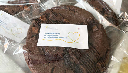 Ein in Klarsichtfolie verpackter Schoko-Coockie mit der Aufschrift "Eine kleine Stärkung für zwischendurch - ein großes Dankeschön für Sie" am Internationalen Tag der Pflegenden in der Immanuel Klinik Rüdersdorf.
