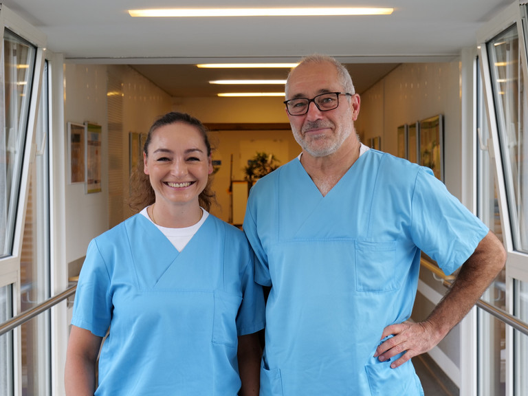 Dr. Anissa Habib-El-Chafchak und Dr. Matthias Gasthaus aus der Klinik für Innere Medizin – Kardiologie im Albertinen Herz- und Gefäßzentrum am Standort Evangelisches Amalie Sieveking Krankenhaus in Hamburg blicken in blauer Funktionskleidung in die Kamera.