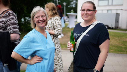 Zwei Mitarbeiterinnen unterhalen sich und blicken in die Kamera beim Sommerfest 2026 auf dem Gesundheitscampus Volksdorf vom Evangelischen Amalie Sieveking Krankenhaus, Residenz am Wiesenkamp, Feierabendhaus Volksdorf und Albertinen Kindertagesstätte Volksdorf. 